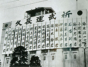 戦時統制下 「祈武運長久」。本社構内に掲示された日中戦争の特派員と応召社員名。